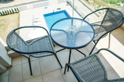 a table and chairs on a balcony with a pool at La Dolce Vita Residence in Ulcinj