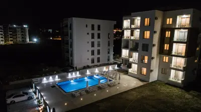 an apartment building with a swimming pool at night at La Dolce Vita Residence in Ulcinj