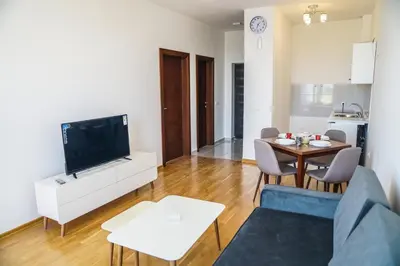 a living room with a television and a table with chairs at La Dolce Vita Residence in Ulcinj
