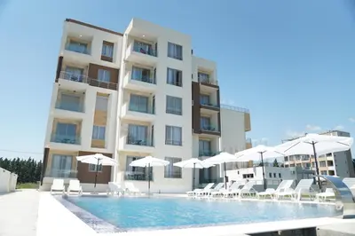 a hotel with a swimming pool with chairs and umbrellas at La Dolce Vita Residence in Ulcinj