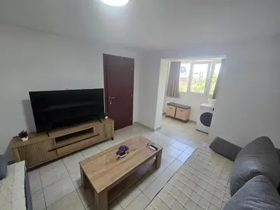 a living room with a flat screen tv and a coffee table at Apartmani Vitic in Bar