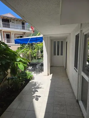 a hallway of a house with a table and a blue umbrella at Apartmani Vitic in Bar