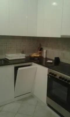 a kitchen with white cabinets and a black counter top at Dvosoban stan, Babin Do, Budva sa garazom in Budva