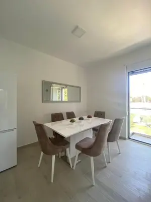 a white dining room with a white table and chairs at Rasi Luxury Apartments in Ulcinj