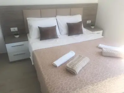 a bedroom with a bed with a remote control on it at Rasi Luxury Apartments in Ulcinj