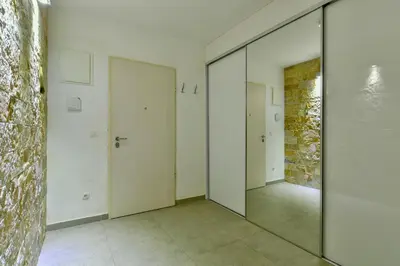 a hallway with mirrored doors and a brick wall at Lux Apartment Luna in Sveti Stefan