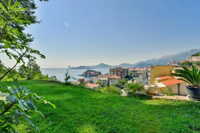 a view of a city from a green hill at Lux Apartment Luna in Sveti Stefan