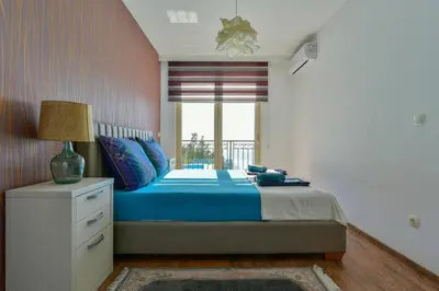 a bedroom with a blue bed and a window at Lux Apartment Luna in Sveti Stefan