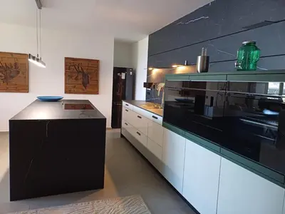 a kitchen with white cabinets and black appliances at Lux Apartment Luna in Sveti Stefan