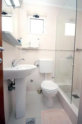 a bathroom with a toilet and a sink and a shower at Apartmani More in Sveti Stefan