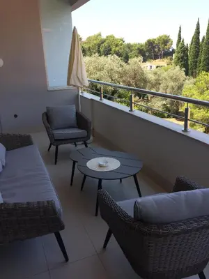 a balcony with a couch and chairs and a table at Harmony in Sveti Stefan