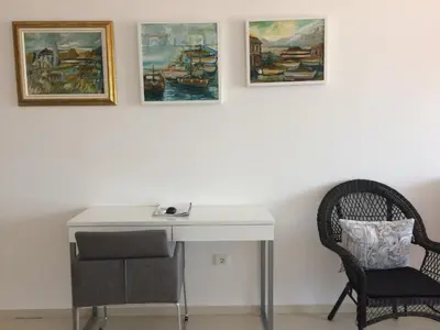 a desk with a chair and paintings on the wall at Harmony in Sveti Stefan
