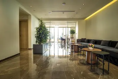 a lobby with a couch and tables and plants at Hotel Harmonia by Dukley in Budva