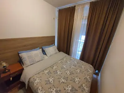a bedroom with a bed and a window at Recently renovated Delta Apartment in Podgorica