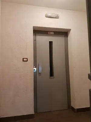 a elevator door in a building with a sign on it at Recently renovated Delta Apartment in Podgorica