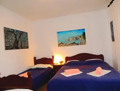 a bedroom with two beds with blue sheets and pink pillows at Apartments Djakonovic in Ulcinj