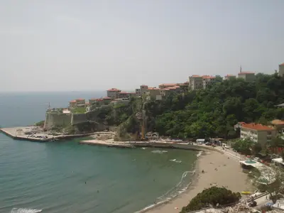 a view of a beach with buildings on a hill at Apartments Djakonovic in Ulcinj