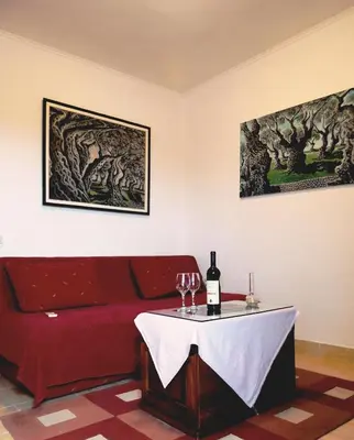 a living room with a red couch and a table with wine glasses at Apartments Djakonovic in Ulcinj