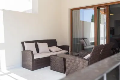 a living room with wicker chairs and a couch at Villa Zen Port in Petrovac na Moru