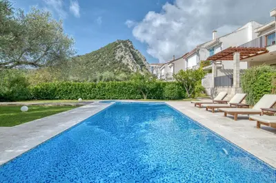 a swimming pool with lounge chairs next to a house at Villa Zen Port in Petrovac na Moru