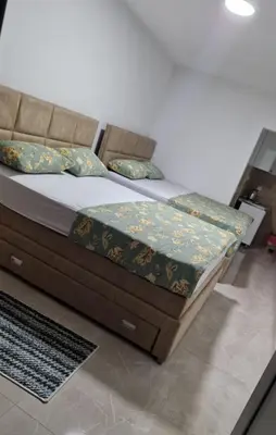 a bed with a wooden frame and pillows on it at Apartmani Maja in Bar