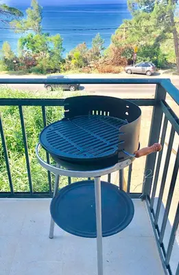 a grill on a balcony with a view of the ocean at Apartmani Maja in Bar