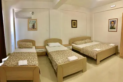 a room with two beds and two chairs in it at Apartmani Maja in Bar