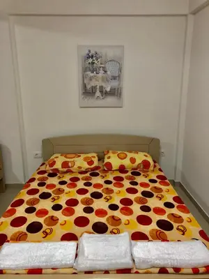a bedroom with a bed with a flower blanket at Apartmani Maja in Bar