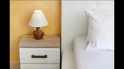 a lamp on a night stand next to a bed at Central Magik Apartments in Kotor