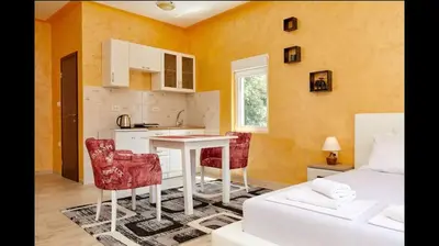 a kitchen and living room with a table and chairs at Central Magik Apartments in Kotor