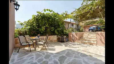 a patio with a table and chairs and a tree at Central Magik Apartments in Kotor