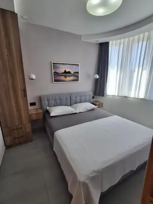 a bedroom with a large bed and a large window at Apartments Grabovica in Bar