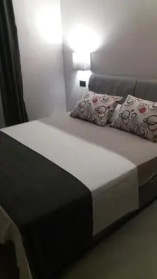 a bed with two pillows on it in a room at Apartments Grabovica in Bar