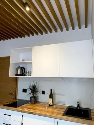 a kitchen with white cabinets and a bottle of wine at Apartments Grabovica in Bar