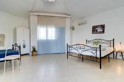 a bedroom with two beds and a table and a chair at FKK Ada Bojana in Ulcinj