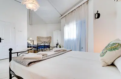 a white bedroom with a bed with towels on it at FKK Ada Bojana in Ulcinj