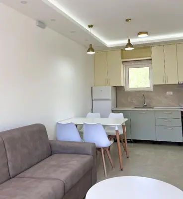 a living room with a couch and a table and a kitchen at Apartments Aura in Utjeha