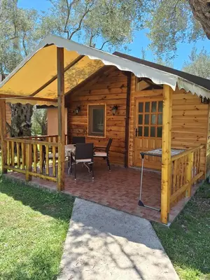 a wooden cabin with a table and a tent at Apartments Aura in Utjeha