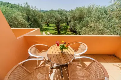 a table with chairs and a vase of flowers on a balcony at Apartments Aura in Utjeha