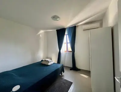 a bedroom with a blue bed and a window at Green Villa in Olives in Bar