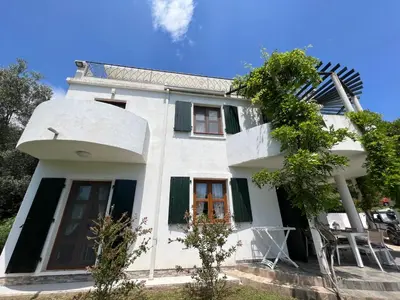 a white house with a tree in front of it at Green Villa in Olives in Bar