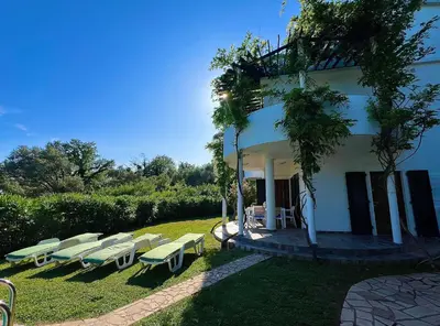 a group of lounge chairs in front of a building at Green Villa in Olives in Bar