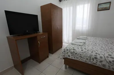 a bedroom with a bed and a flat screen tv at Apartments Memidz in Budva
