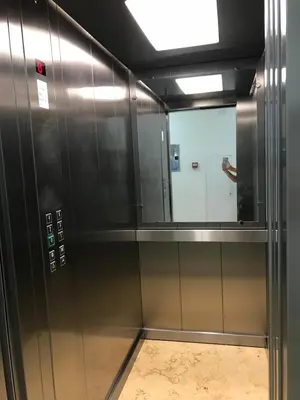 a metal elevator with a mirror in a room at Apartmani Belma in Dobra Voda
