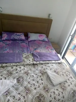 a bedroom with a bed with purple sheets at Apartmani Belma in Dobra Voda
