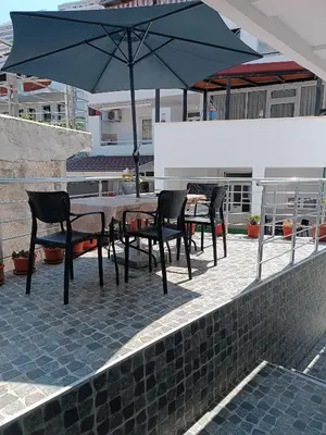 a table and chairs with an umbrella on a patio at Accommodation Milla in Ulcinj