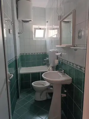 a green and white bathroom with a toilet and a sink at Accommodation Milla in Ulcinj