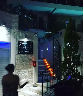 a person walking down the stairs of a house at night at Apartments M Palace in Budva