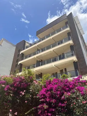 a building with pink flowers in front of it at Apartments M Palace in Budva
