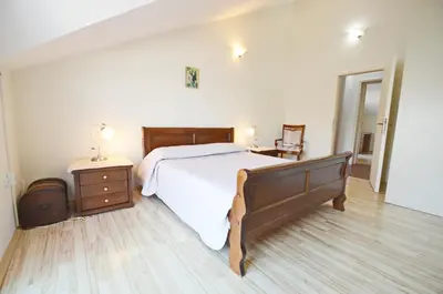 a bedroom with a large bed and a wooden floor at Dubravcevic Residence in Tivat